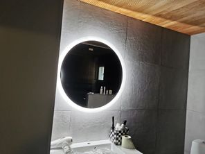 Kylpyhuoneen seinä ja valaistu peili